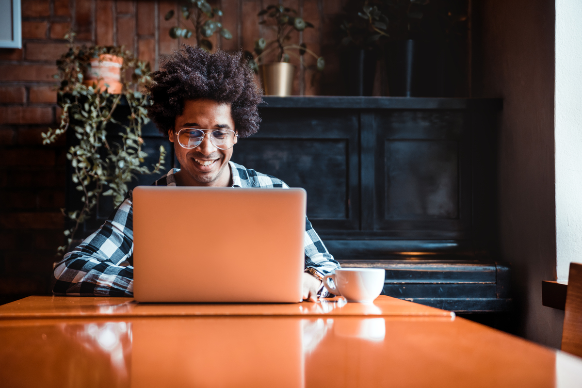 man wearing glasses typing on a laptop