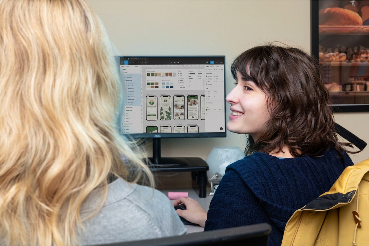 two coworkers looking at design on a computer