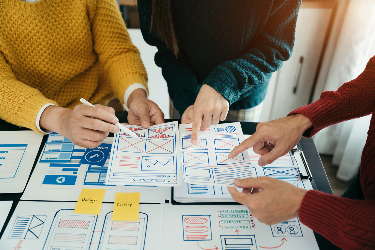 creative team going over website mockups and wireframes on paper