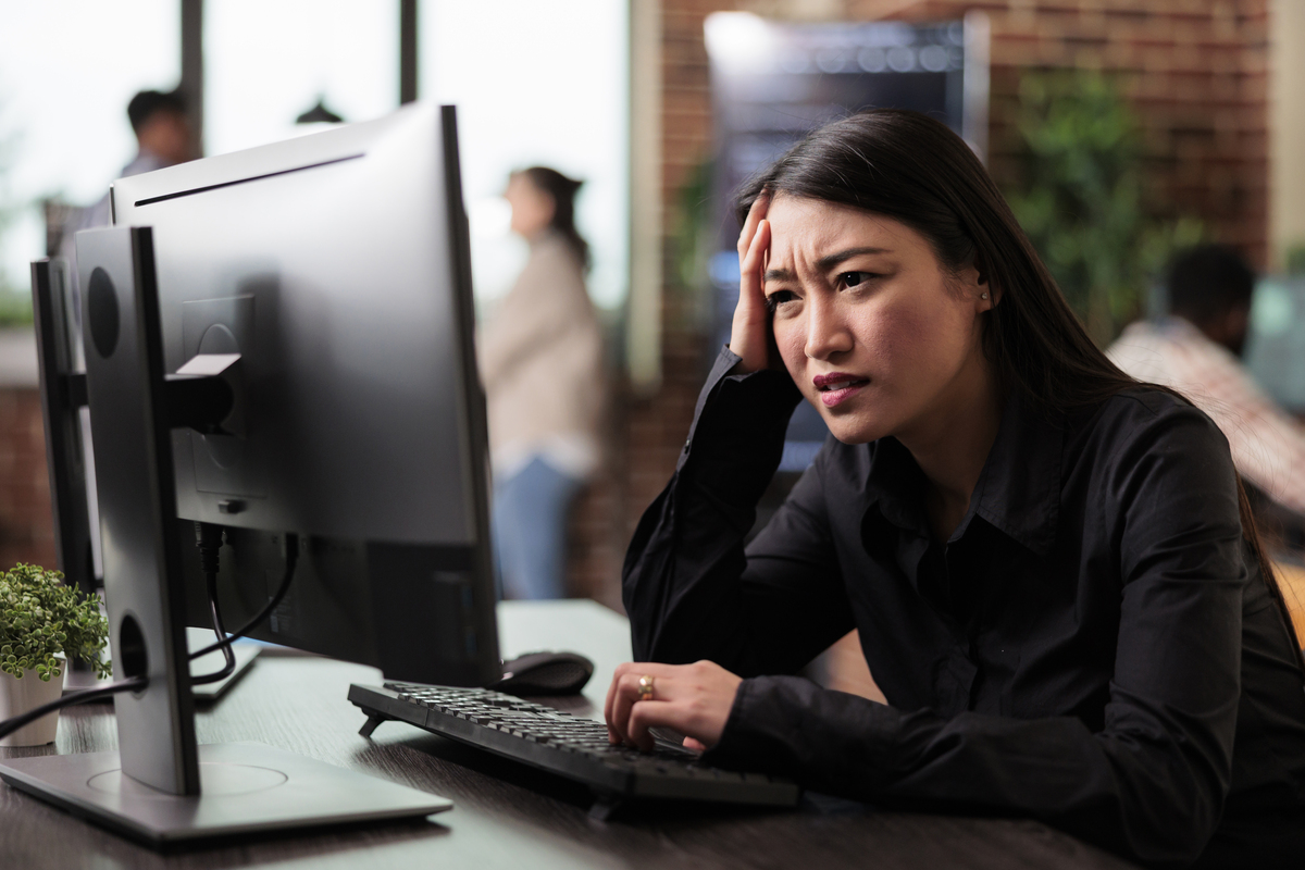 woman looking at her computer in frustration