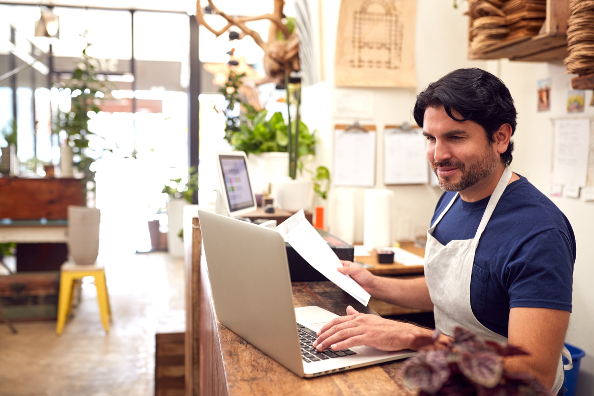 business owner of retail store looking on laptop