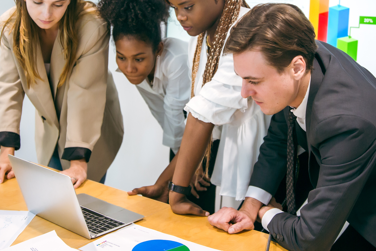 a group of people looking at a laptop computer