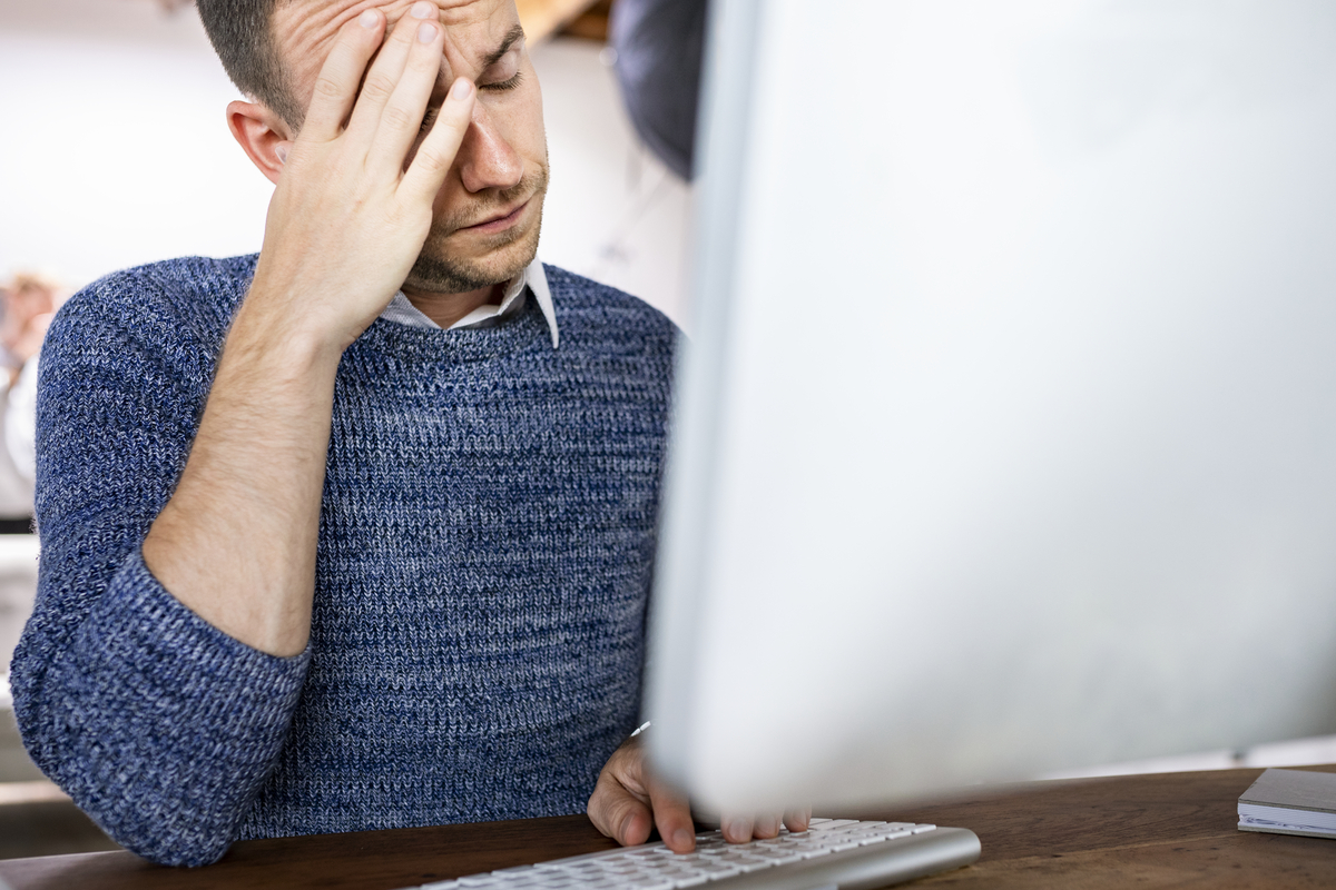 man lookin stressed in front of his computer