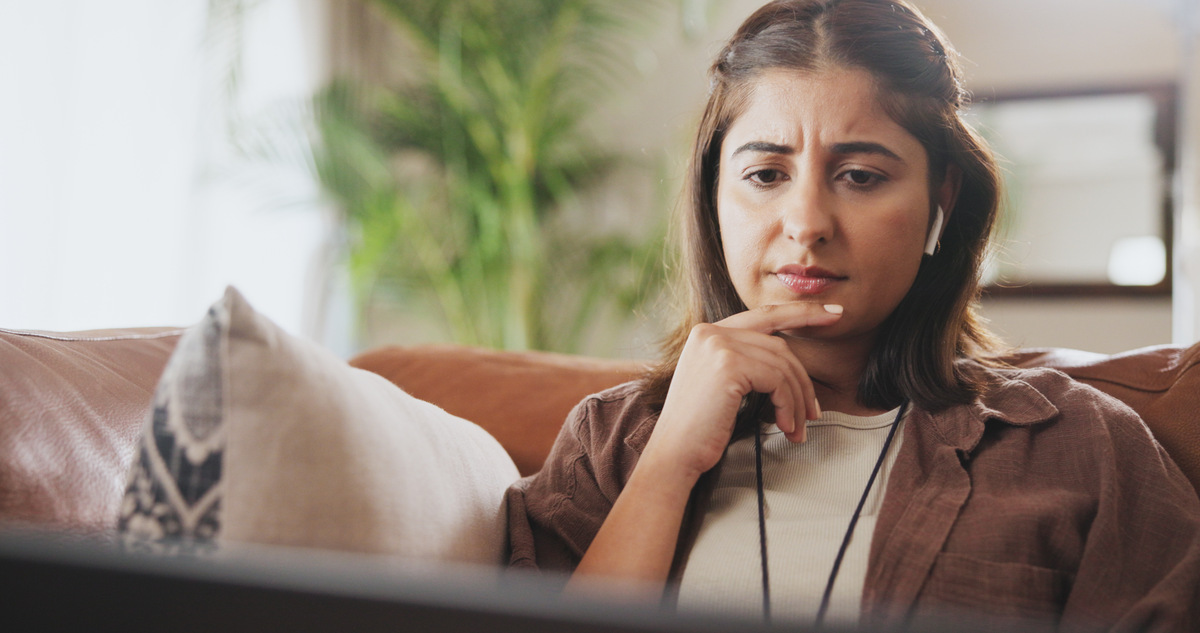 woman looking thoughtfully at her laptop