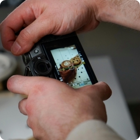 taking a photo of coffee and a cookie on a digital camera