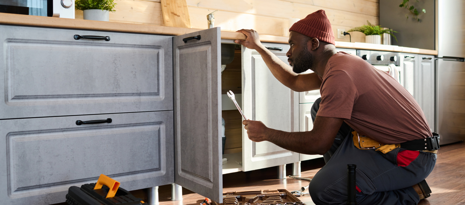 Plumber working under cabinets